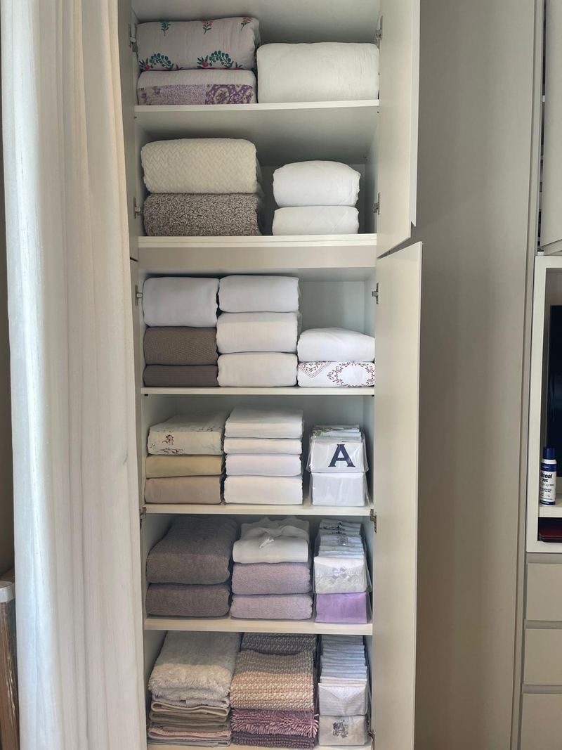 The same linen closet with towels and linens folded uniformly and arranged by type