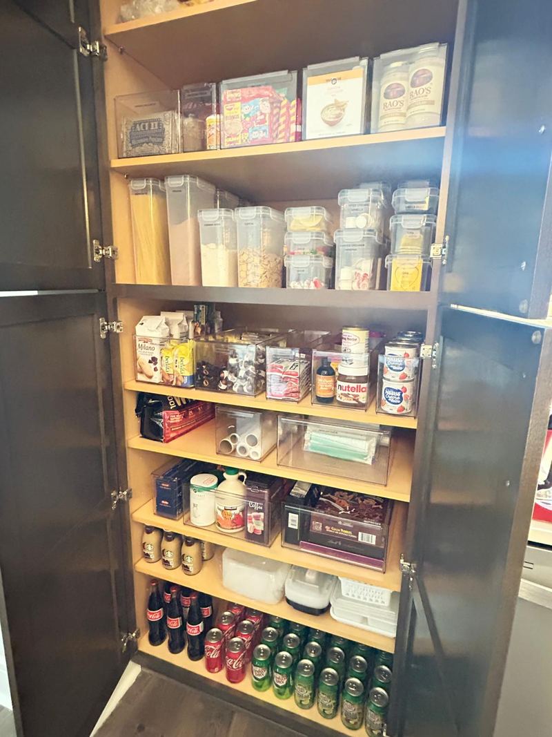 The same pantry with food sorted into clear, labeled containers by category