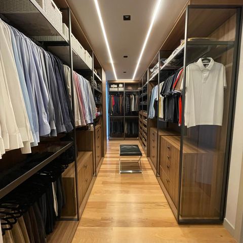 Luxury walk-in closet with wood cabinetry and LED lighting