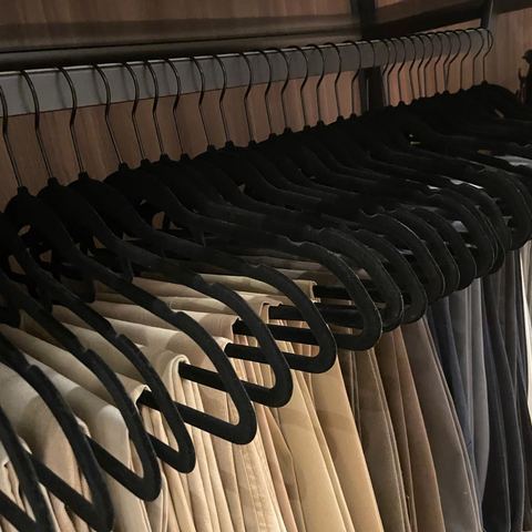 Trousers hung evenly on matching black velvet hangers